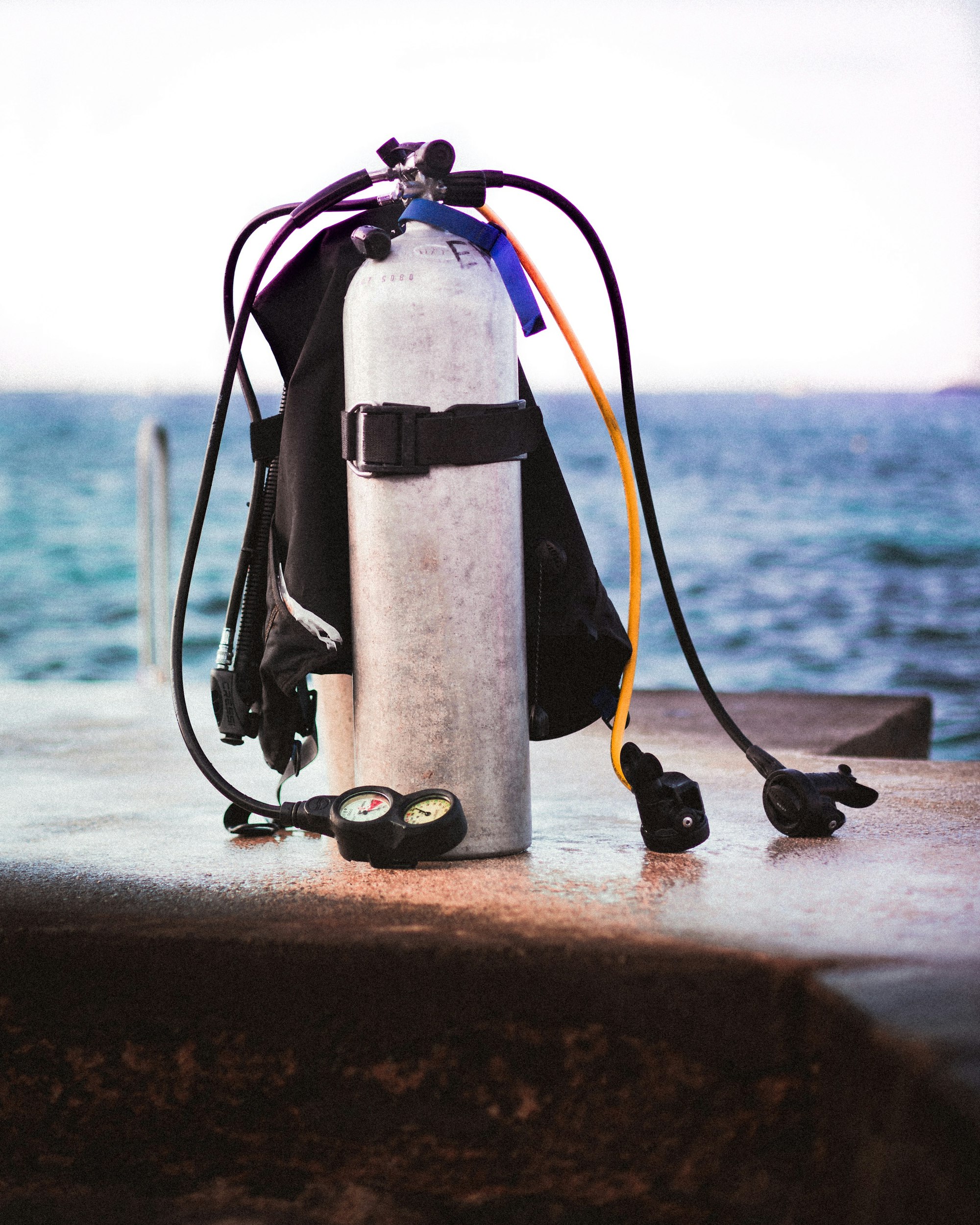 Scuba diving tank and breathing equipment beside the sea.
